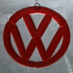 A red volkswagen logo hanging from a window.