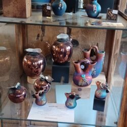 A display of pottery in a glass case.